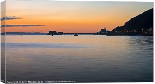 Mumbles lighthouse and pier at sunrise Canvas Print by Bryn Morgan