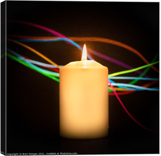 Burning candle with streaks of coloured light Canvas Print by Bryn Morgan