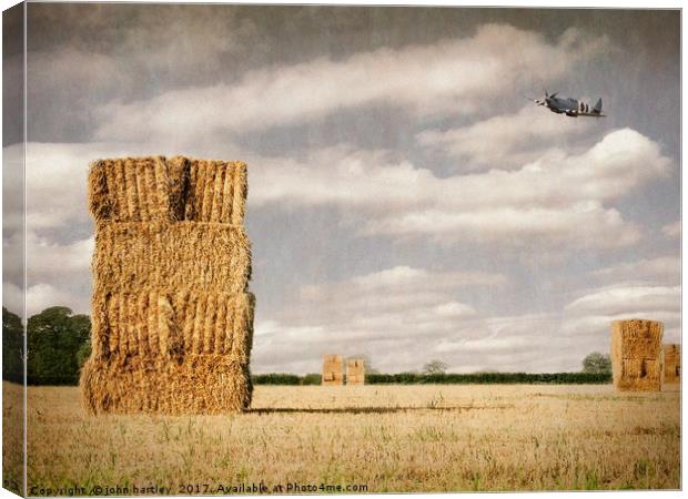  Spitfire at low level over a Cornfield with Hayst Canvas Print by john hartley