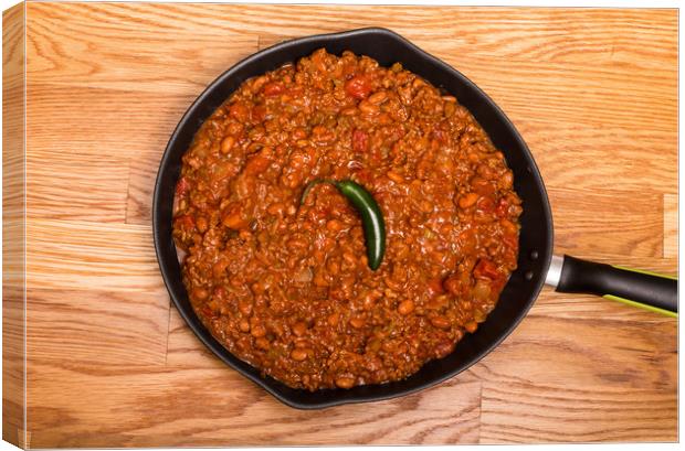 Chili in Black Pan on Wood Table with Jalapeno Pep Canvas Print by Darryl Brooks