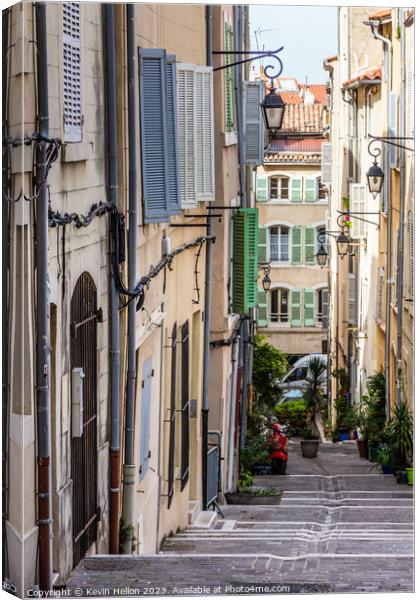 Steep, narrow street in old Marseille, France Canvas Print by Kevin Hellon