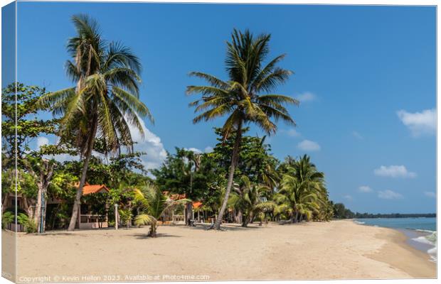 Resort on tropical beach with palm trees in Chumph Canvas Print by Kevin Hellon