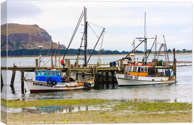  Fishing boats moored at a pier Canvas Print by Kevin Hellon