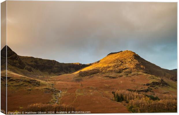 Majestic vibrant Autumn Fall landscape Buttermere in Lake District with beautiful early morning sunlight playing across the hills and mountains Canvas Print by Matthew Gibson