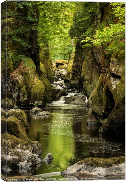 Stunning ethereal landscape of deep sided gorge with rock walls and stream flowing through lush greenery Canvas Print by Matthew Gibson