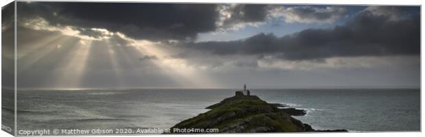 Landscape panorama of Mumbles lighthouse in Wales with sunbeams over sea Canvas Print by Matthew Gibson