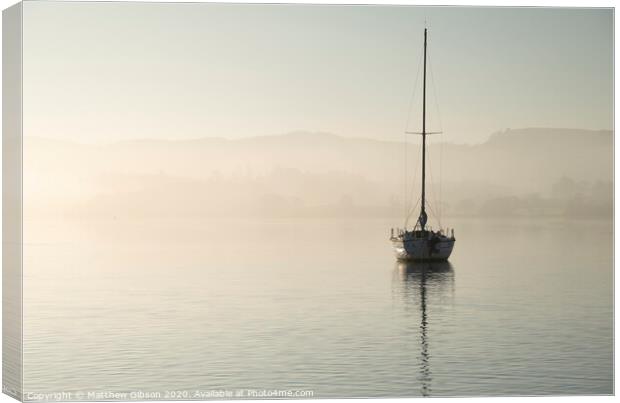 Stunning unplugged fine art landscape image of sailing yacht sitting still in calm lake water in Lake District during peaceful misty Autumn Fall sunrise Canvas Print by Matthew Gibson
