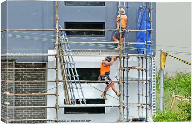 Construction workers dismantling scaffolding on new construction Canvas Print by Geoff Childs