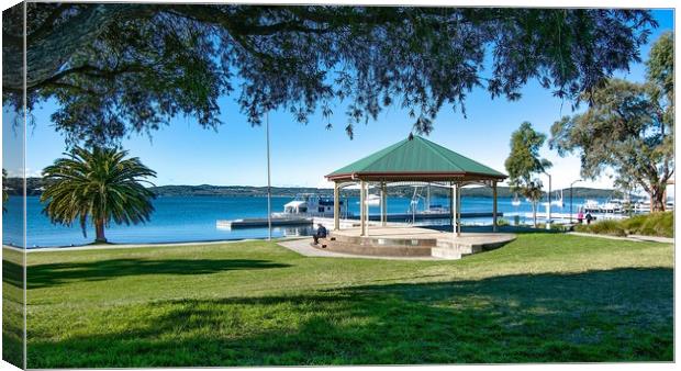  Lush green grassy waterfront park with a quaint l Canvas Print by Geoff Childs
