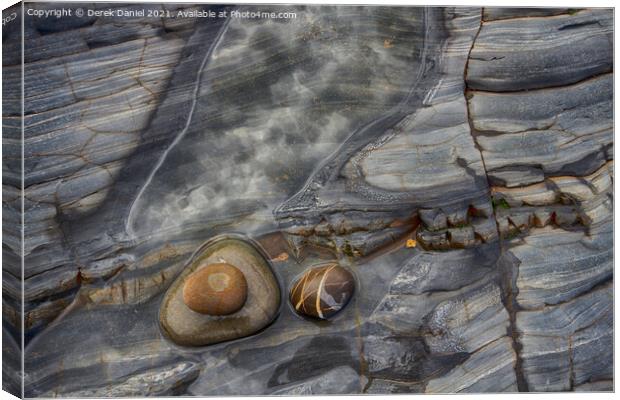 Rocks on the beach at Sandymouth Canvas Print by Derek Daniel