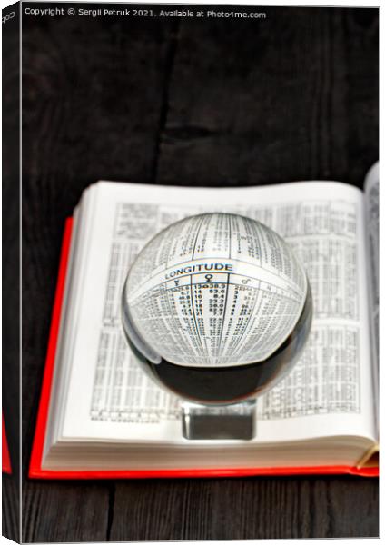 Crystal ball and opened book of ephemeris on blurred black wooden background. Canvas Print by Sergii Petruk