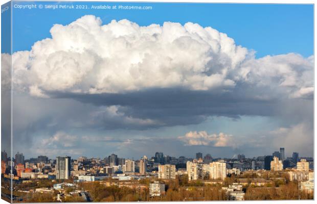 A large white-gray cloud hung over the city and was illuminated by the spring sunbeams. Canvas Print by Sergii Petruk