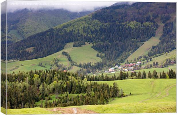 Carpathians. Mountain landscape. Village in the valley among coniferous forests Canvas Print by Sergii Petruk