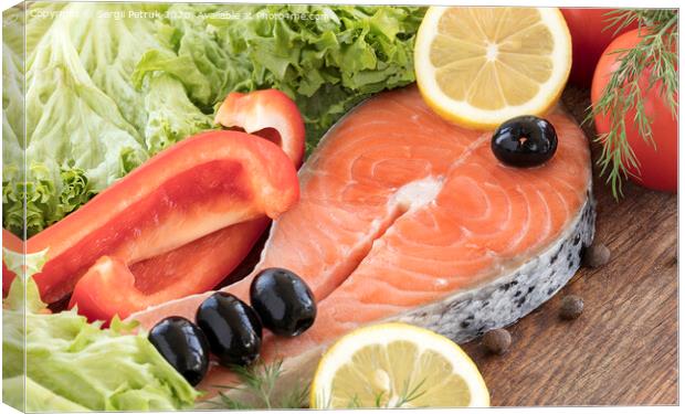 Raw salmon steak on a wooden board surrounded by vegetables, black olives and spices. Canvas Print by Sergii Petruk
