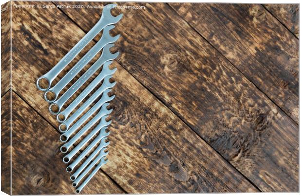set of wrench against old wooden boards background Canvas Print by Sergii Petruk