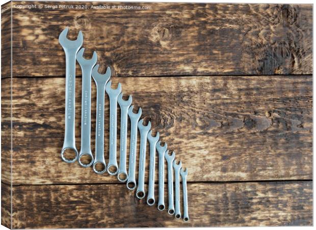 set of wrench against old wooden boards background Canvas Print by Sergii Petruk