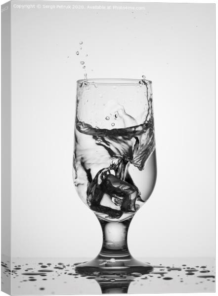 An ice cube falls into a glass glass with water Canvas Print by Sergii Petruk