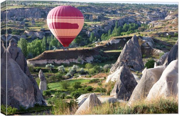 A balloon is flying over the valley in Cappadocia Canvas Print by Sergii Petruk
