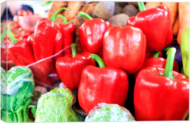 Large red sweet bell peppers on the background of other vegetables sold on the market Canvas Print by Sergii Petruk