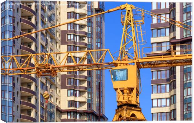 Crane between the facades and near the modern residential building under construction. Canvas Print by Sergii Petruk