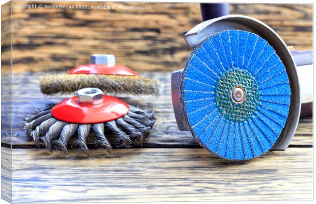 Angle grinder with grinding disc brushes lies on the background of a wooden table. Canvas Print by Sergii Petruk
