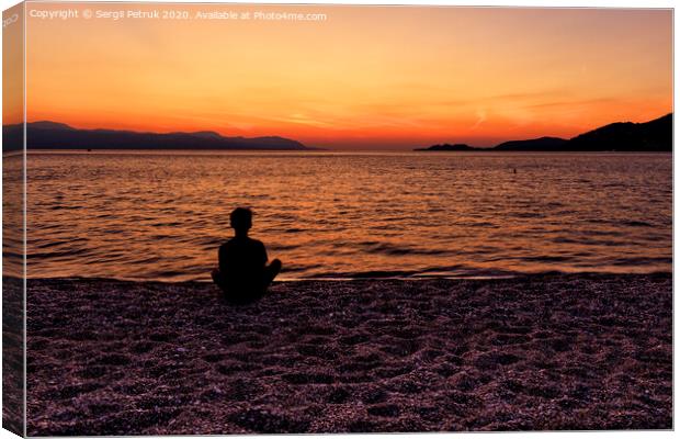 Silhouette of a teenager sitting on the seashore and watching a beautiful, bright sunset on the Gulf of Corinth. Canvas Print by Sergii Petruk