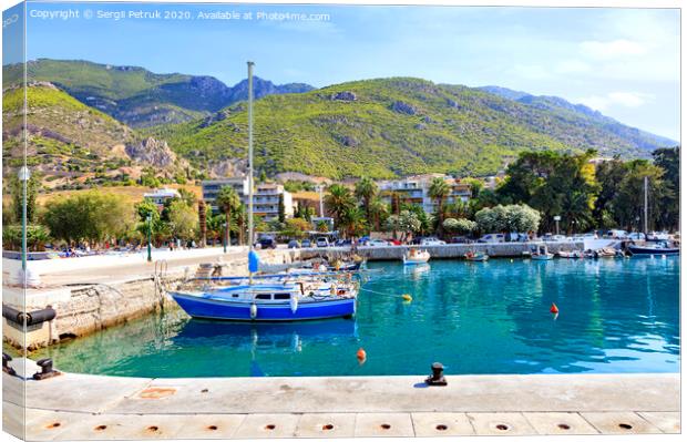 View of the pier of the bay, where old fishing schooners, boats and boats are moored in the clear waters of the Ionian Sea. Canvas Print by Sergii Petruk