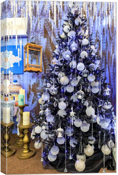Christmas toys and stars, Christmas tinsel, decorative icicles and blue lights hang on a Christmas tree. Canvas Print by Sergii Petruk