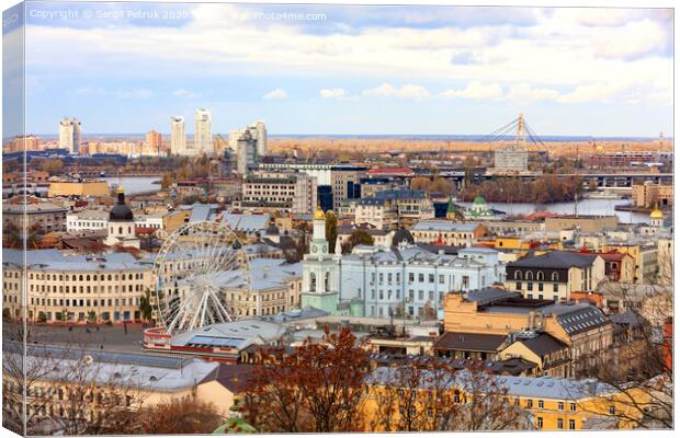 The landscape of the autumn city of Kyiv overlooking the old district of Podil with a Ferris wheel and a bell tower with a gilded dome, the Dnipro River and many bridges. Canvas Print by Sergii Petruk