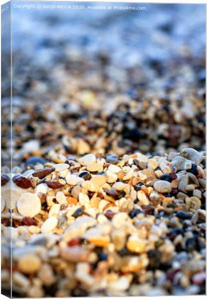 Beach pebbles backlit by a bright sunbeam. Canvas Print by Sergii Petruk