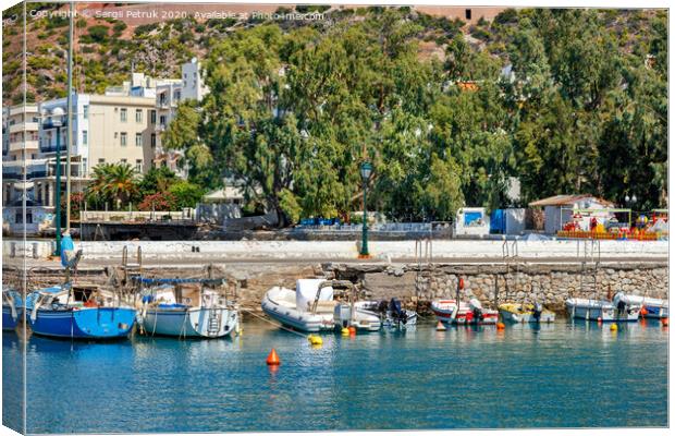 The picturesque promenade of Loutraki Bay, Greece, where old fishing schooners, boats and boats moor in the clear waters of the Ionian Sea. Canvas Print by Sergii Petruk