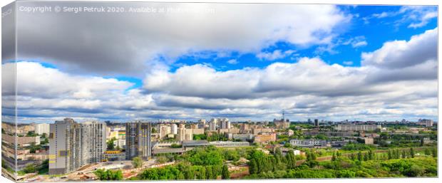 Panorama of cityscape with big low clouds and bright sunlight. Canvas Print by Sergii Petruk