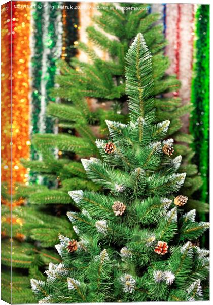 Artificial Christmas pine on a background of multicolored tinsel in blur. Canvas Print by Sergii Petruk