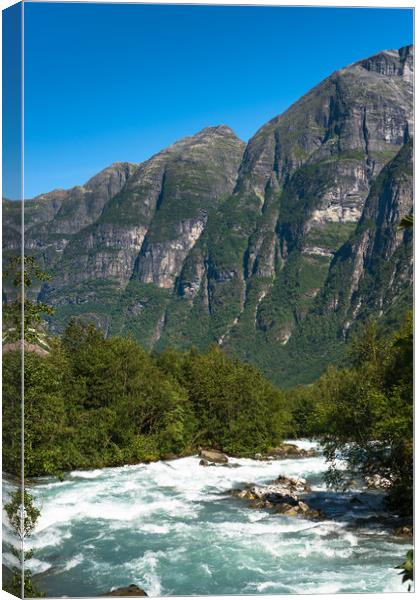 River through the mountains near Briksdals Glacier Canvas Print by Andrew Michael