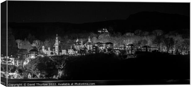 The lights of the Italianate village of Portmeirion illuminate the surrounding trees Canvas Print by David Thurlow