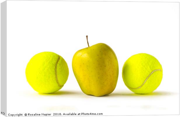 Yellow apple between two tennis balls Canvas Print by Rosaline Napier