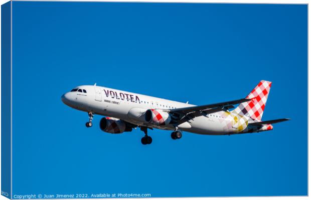 Airbus A320 passenger aircraft of the airline Volotea flying before landing against sky Canvas Print by Juan Jimenez