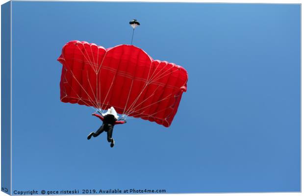 parachutist with red parachute on blue sky Canvas Print by goce risteski