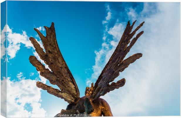 A sculpture of an angel, rear view of its wings against the sky. Canvas Print by Joaquin Corbalan