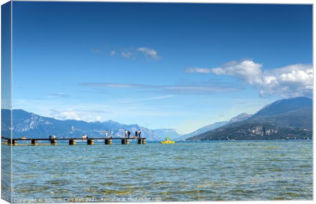 Calm water lake in Garda, Italy with a wooden walkway on a sunny Canvas Print by Joaquin Corbalan