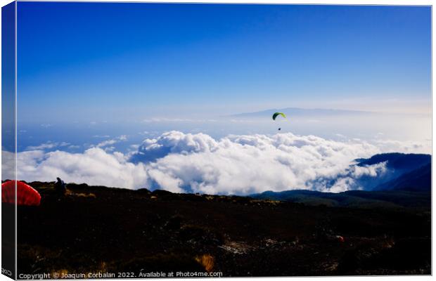 Paragliding above mountain peaks and white clouds during winter  Canvas Print by Joaquin Corbalan