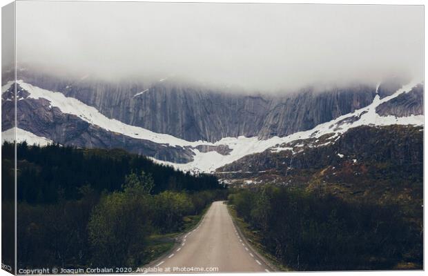 Challenging road to a rocky mountain with fog Canvas Print by Joaquin Corbalan