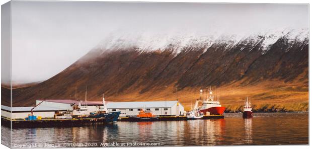 Fishing port of the village of Seydisfjordur, in Iceland, with vibrant colors and reflections in the sea of fishing boats. Canvas Print by Joaquin Corbalan