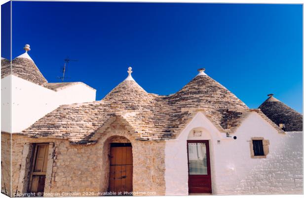 Houses of the tourist and famous Italian city of Alberobello, with its typical white walls and trulli conical roofs. Canvas Print by Joaquin Corbalan