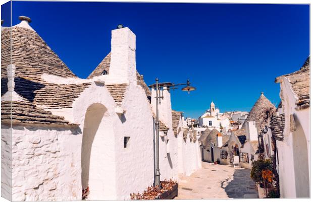 Narrow streets between the trulli of Alberobello, in southern Italy, ideal for family trips. Canvas Print by Joaquin Corbalan