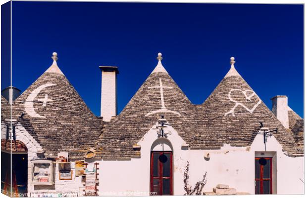 Roofs with symbols in the trulli, in the famous Italian city of Alberobello. Canvas Print by Joaquin Corbalan