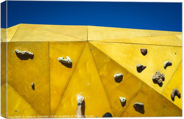 Young man grabs to try climbing on an outdoor climbing wall in a park in Valencia. Canvas Print by Joaquin Corbalan