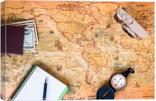 A traveler plans his trip around the world on an old map, while taking notes to get inspired. Canvas Print by Joaquin Corbalan
