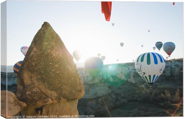 Colorful balloons flying over mountains and with blue sky in cappadocia. Canvas Print by Joaquin Corbalan
