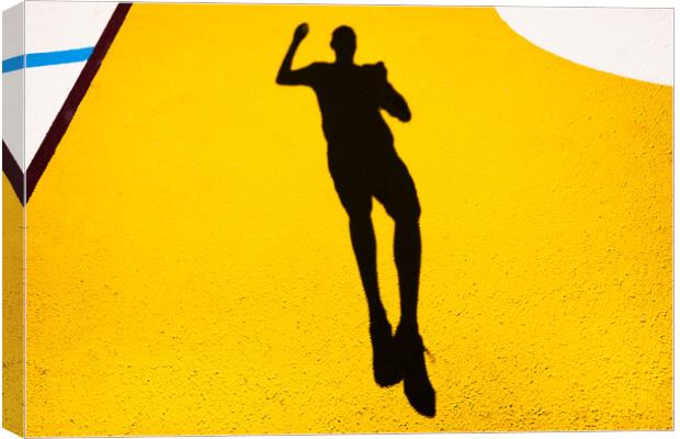 Shadow and silhouette of a man jumping on a yellow painted floor. Canvas Print by Joaquin Corbalan